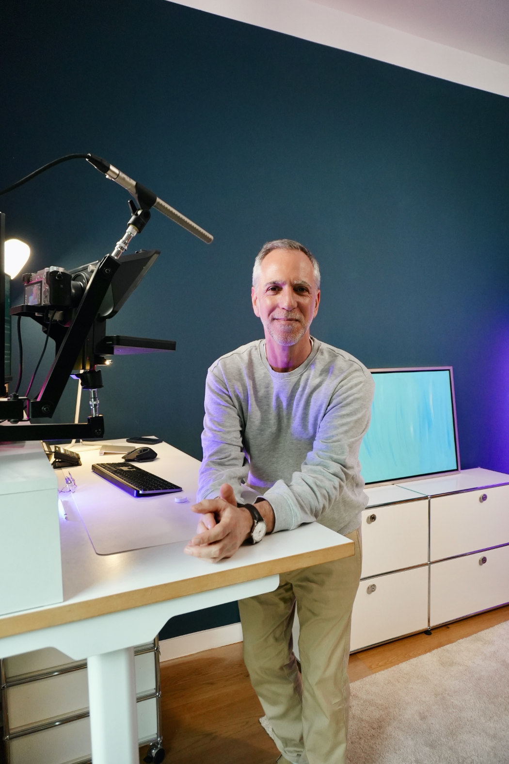 Markus Tirok steht am Schreibtisch vor seinem Online-Setup